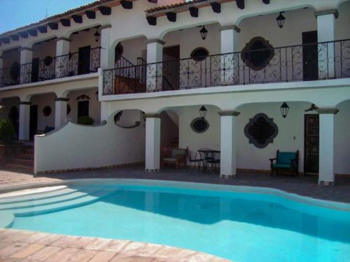 a villa with a swimming pool in front of a building at Hotel Parador del Cortijo Spa in San Miguel de Allende