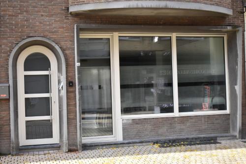 a store front with two windows and a door at De Zandparel in De Panne