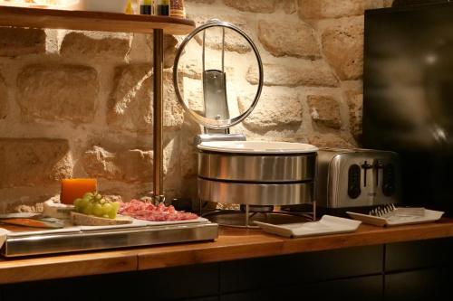 a kitchen counter with a toaster and some food at Hôtel de Bellevue Paris Gare du Nord in Paris