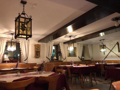 een restaurant met tafels en stoelen en een kroonluchter bij Gasthof Adler in Schillingsfürst