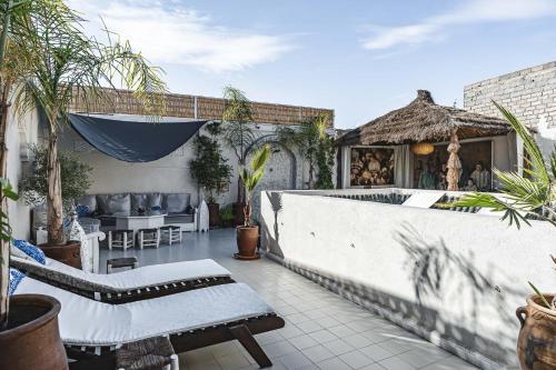 a patio with a table and chairs and a couch at Riad Aguaviva in Marrakech