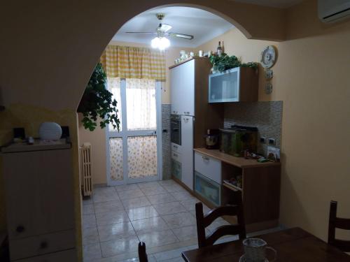 eine Küche mit einem Torbogen, der in eine Küche mit einem Tisch führt in der Unterkunft A CASA MIA in San Giorgio Ionico