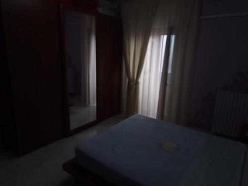 ein dunkles Zimmer mit einem Bett und einem Fenster in der Unterkunft A CASA MIA in San Giorgio Ionico