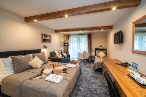 a living room with a couch and a table at Pensjonat Orlik Mountain Resort&SPA in Bukowina Tatrzańska