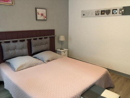 a bedroom with a bed and a table with a lamp at Le Paillot de Montabert Hyper Centre classé in Troyes