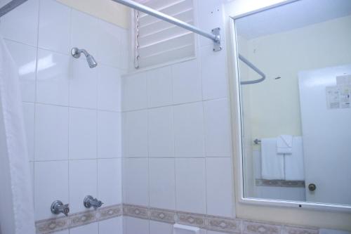 a bathroom with a shower and a mirror at Clearwater Studio @ Sandcastles in Ocho Rios