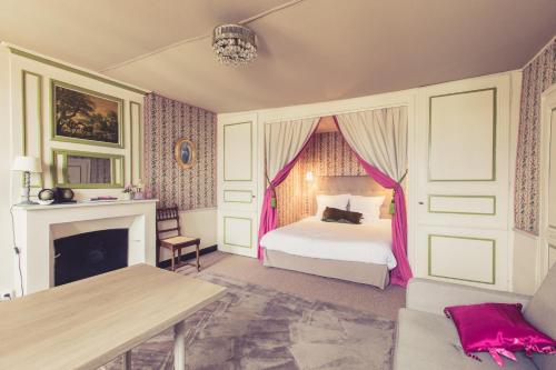 ポワティエにあるLa Maison de la Liberté Alexandra David-Néelのベッドルーム1室(ピンクのカーテンと暖炉付きのベッド1台付)