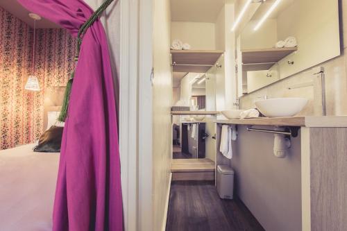 ポワティエにあるLa Maison de la Liberté Alexandra David-Néelのベッド1台、ピンクのカーテンが備わる客室です。