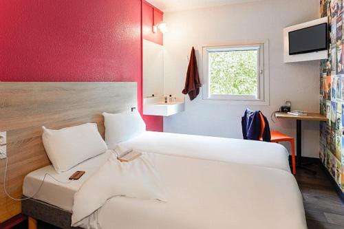 a hotel room with a bed and a window at hotelF1 Les Ulis Courtaboeuf in Les Ulis