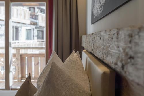 a couch with pillows in a room with a window at The Lodge by Regina in Sölden