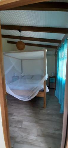 a bedroom with a bunk bed with a canopy at Gîte "Avocatier" in Bouillante