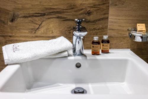 a bathroom sink with a towel and a faucet at Pensjonat Orlik Mountain Resort&SPA in Bukowina Tatrzańska