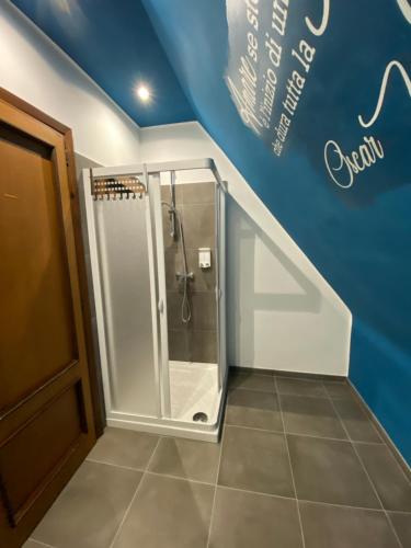 a walk in shower in a bathroom with a blue wall at Campobasso 30E in Campobasso