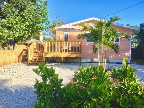 a house with a wooden deck with an umbrella at Coastal Studio Escape! in Naples