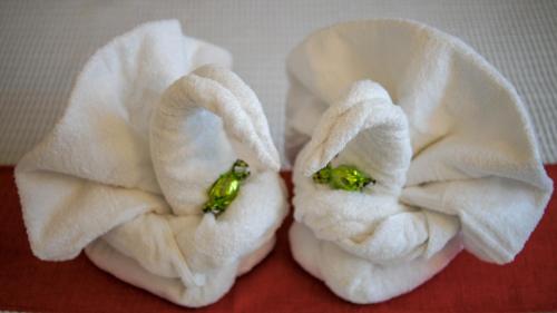 two white towels with broccoli in them on a table at Lovewknds - Topfloor with Duomo View in Florence