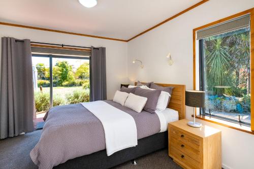 a bedroom with a bed and a large window at Lawn Cottages in Clive