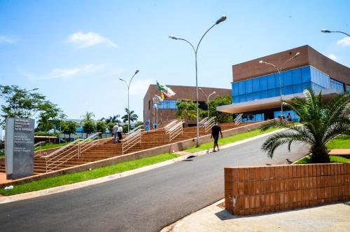 a person riding a skateboard down a road in front of a building at Hotel Winner in Barretos