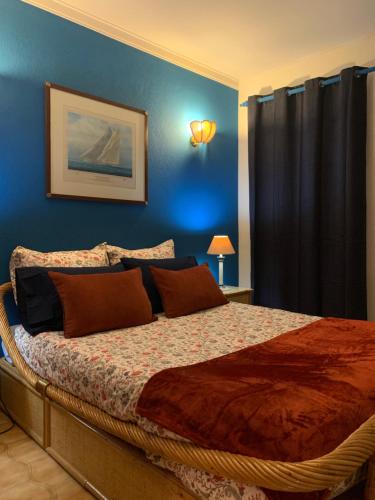 a bedroom with a large bed with a blue wall at Casa vista Azul in Sesimbra