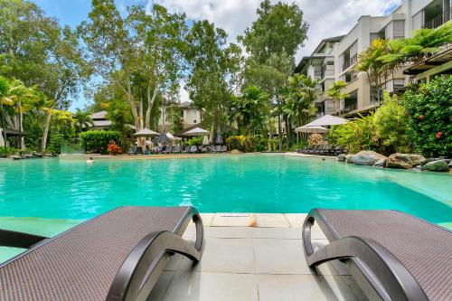 a swimming pool with blue water in a building at Swim Out Apartments in Triton Street Beachfront Resort Palm Cove in Palm Cove