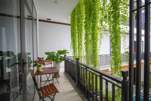 uma varanda com uma mesa e uma planta em Serenity Villa Hoi An em Hoi An