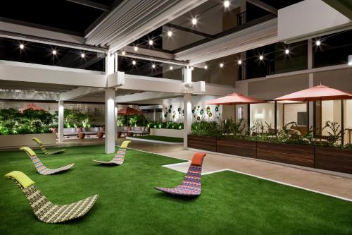a lobby with chairs on the grass at Halepuna Waikiki by Halekulani - NO RESORT FEE in Honolulu