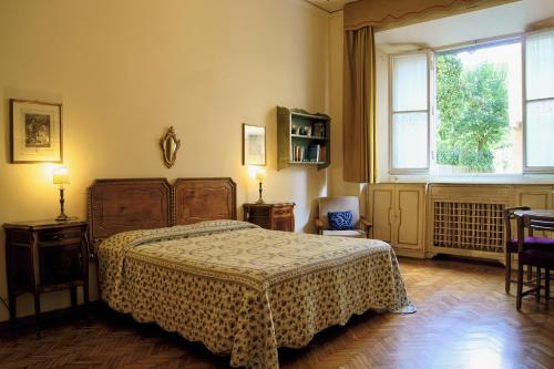 a bedroom with a bed and a large window at Bartolomeo in Florence