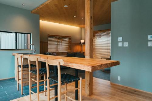 a kitchen with a wooden table and chairs at 三上勘兵衛本店 Mikami Kanbe Honten in Miyazu