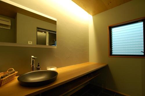 a bathroom with a black sink and a window at 三上勘兵衛本店 Mikami Kanbe Honten in Miyazu