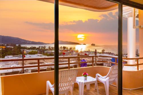 a balcony with a view of the ocean at sunset at Enjoy Sunset Rainbow Alley - WOW Townhouse at Patong Hill in Patong Beach