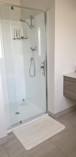 a shower with a glass door in a bathroom at Cambridge Retreat in Cambridge