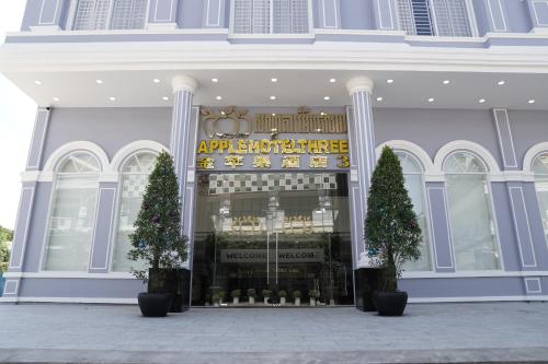 a store front of a building with trees in front at Apple Hotel Three - Phnom Penh in Phnom Penh