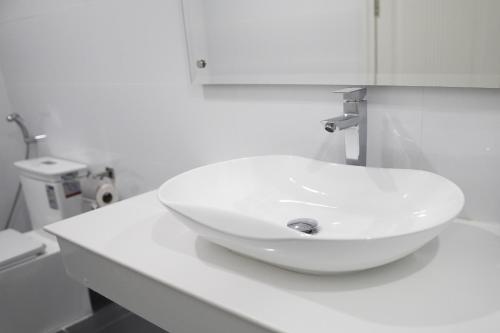 a white sink on a counter in a bathroom at Apple Hotel Three - Phnom Penh in Phnom Penh