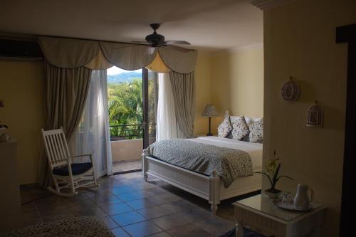 a bedroom with a bed and a large window at Hacienda Los Molinos Boutique Hotel & Villas in Boquete