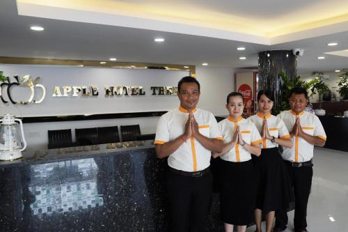 a group of men in ties standing in front of a counter at Apple Hotel Three - Phnom Penh in Phnom Penh