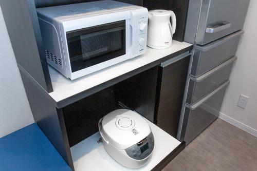 a microwave oven sitting on top of a counter at LAPIN MIHAMA Residence Hotel in Chatan