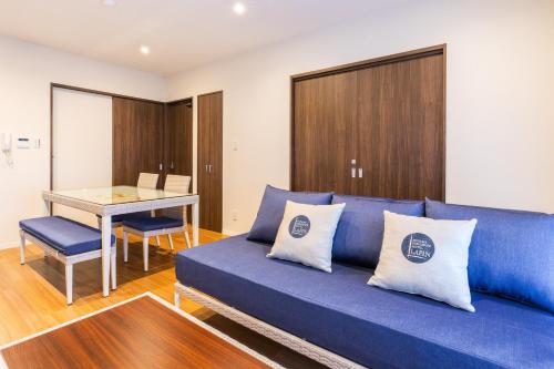 a living room with a blue couch and a table at LAPIN MIHAMA Residence Hotel in Chatan