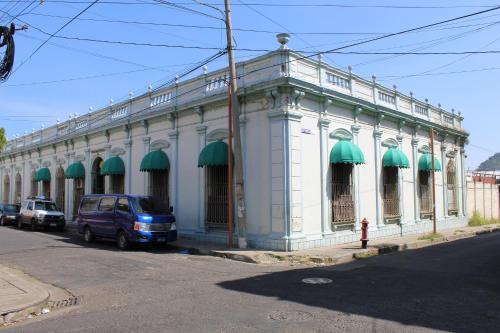 Un edificio blanco con toldos verdes en una calle. en Hostal VELVET PLAZA, en Santa Ana