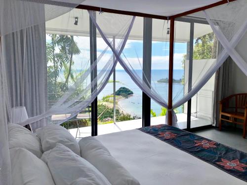 a bedroom with a bed with a view of the ocean at Air Manis Hill Residence in Padang