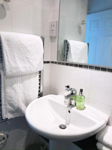 a bathroom with a white sink and a mirror at Seabreeze Restaurant With Rooms in Aberdyfi