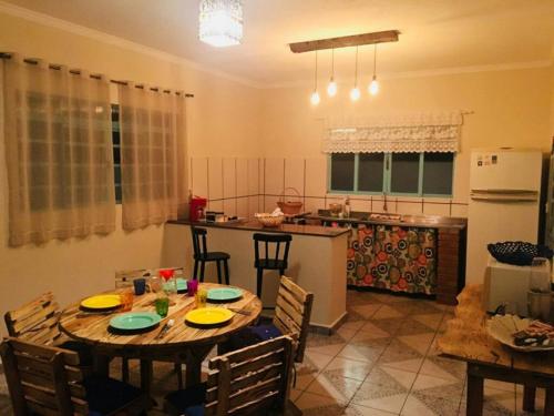 a kitchen with a table with chairs and a kitchen with a refrigerator at Aconchego e conforto em Joanópolis in Joanópolis