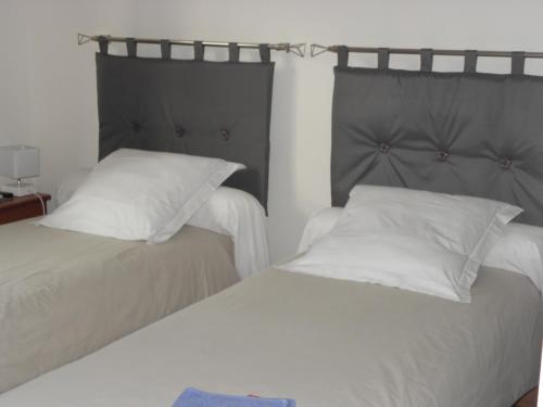 two beds sitting next to each other in a bedroom at La planche pinçon in Teloché