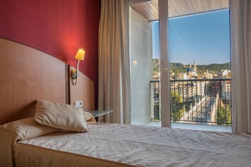 a hotel room with a bed and a large window at Hotel Reconquista in Alcoy