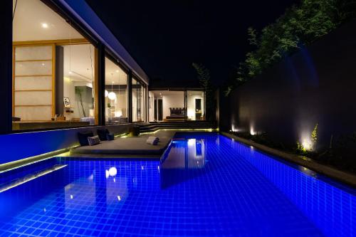 a swimming pool in the middle of a house at night at Villa Kyoto in Layan Beach