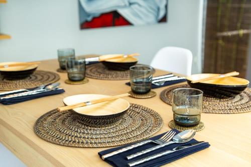 a wooden table with plates and bowls and glasses on it at Villa Kyoto in Layan Beach