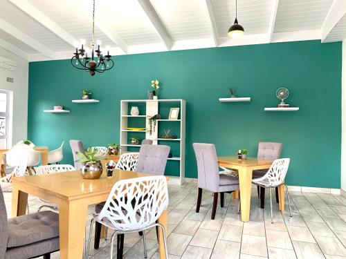 a dining room with blue walls and a table and chairs at Resthaven Guest House in Mthatha
