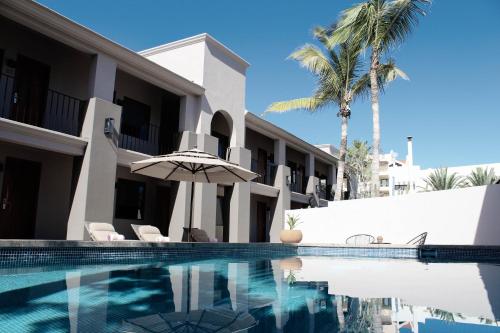 a villa with a swimming pool and palm trees at SIX TWO FOUR Urban Beach Hotel in San José del Cabo