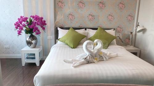 una camera da letto con due cigni bianchi seduti su un letto di The courtyard khaoyai by Tom a Mu Si