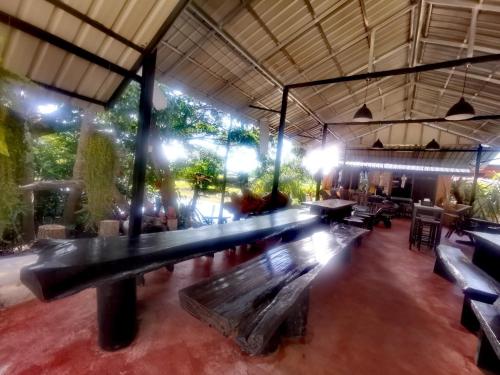 a ping pong table in a restaurant with benches at Ban Din Resort Chiang Rai in Mae Chan