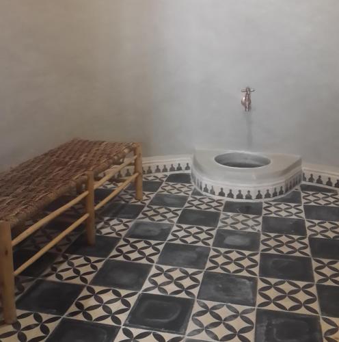 a bathroom with a toilet on a black and white floor at Dar Essaada in Essaouira