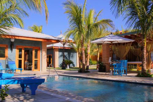 dom z basenem z niebieskimi krzesłami i parasolem w obiekcie Thermas Park Resort & SPA by Hot Beach w mieście Olímpia